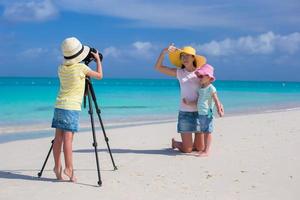 Little girl making photo of her family at the beach