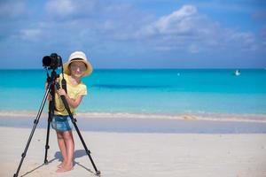 niña disparando con cámara en trípode durante sus vacaciones de verano foto