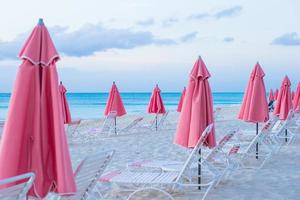 Paradise view of tropical empty sandy plage with umbrella and beach chair photo