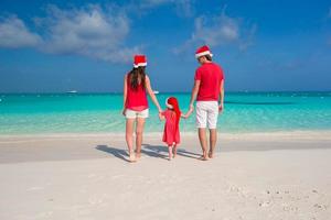 Happy family in Santa Hats having fun during caribbean vacation photo