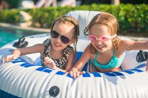 Little adorable girls swimming in the swimmingpool photo