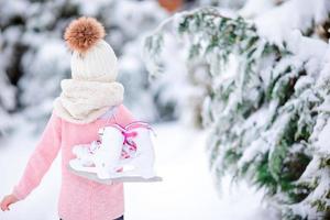 Cute little kid girl is going skate outdoors. photo