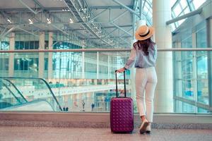 mujer joven con sombrero con equipaje en el aeropuerto internacional. foto