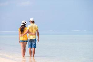 Happy family walking along the ocean on the beach photo