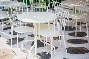 mesas blancas con sillas en el café al aire libre vacío de verano en grecia foto