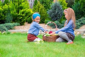 dos niñas felices con gran cosecha otoñal de tomates en cestas foto