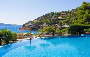 Deck chairs and infinity pool over amazing tropical lagoon photo