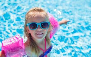 Adorable happy little girl have fun in the swimming pool photo