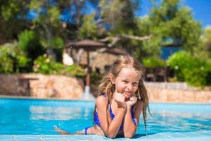 Adorable happy little girl have fun in the swimming pool photo