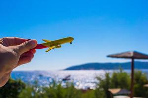 Small plane in female hand on background of blue sky photo