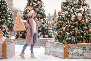 niña feliz cerca de la rama de abeto en la nieve para año nuevo. foto