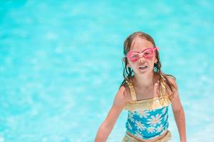 Little adorable girl in outdoor swimming pool photo