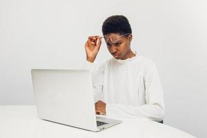 mujer negra usando una computadora portátil en la oficina foto