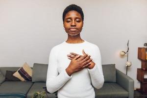 black woman feeling his heart at home photo