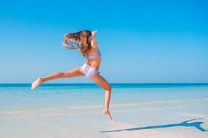 niña activa en la playa divirtiéndose mucho. foto