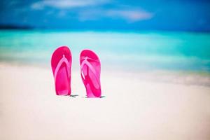Colorful flipflop pair on the sea beach photo