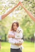 Little smiling girl playing and hugging puppy in the park photo