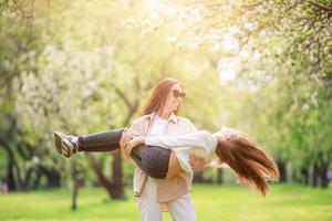 Family of mother and daughter in blooming cherry garden photo