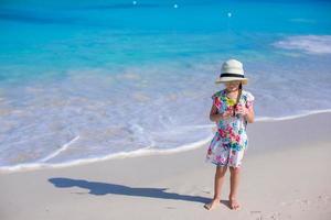 Adorable girl at white beach during summer vacation photo