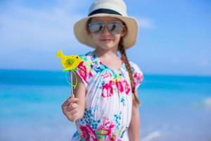 Happy little girl in hat on beach during summer vacation photo