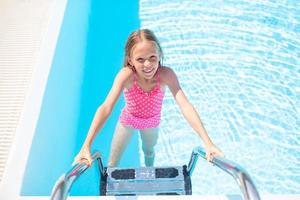 adorable niña nadando en la piscina al aire libre foto