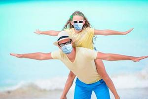 Little girl and happy dad having fun during beach vacation photo