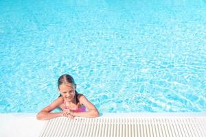 Little adorable girl in outdoor swimming pool photo