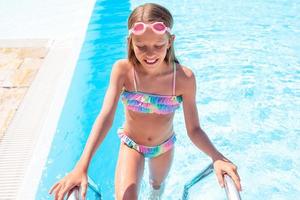 Little adorable girl in outdoor swimming pool photo