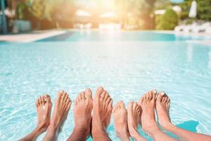 Close up of four people's legs by pool side photo