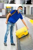 Young man in an airport lounge waiting for flight aircraft. photo