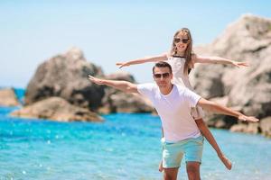 niña y papá feliz divirtiéndose durante las vacaciones en la playa foto