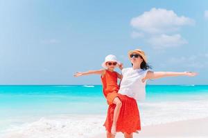 hermosa madre e hija en la playa caribeña disfrutando de las vacaciones de verano. foto