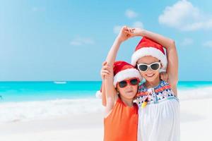 Adorable little girls with starfish on white empty beach photo