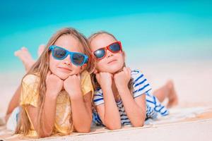 Little happy funny girls have a lot of fun at tropical beach playing together. photo