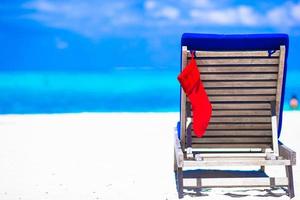 Red Christmas stocking on chair at outdoor cafe background the sea photo