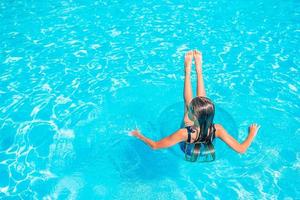 Little adorable girl in outdoor swimming pool photo