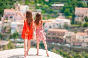 Adorable little girls on warm and sunny summer day in Positano town in Italy photo