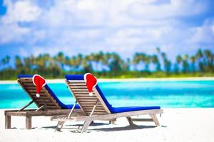 Red Santa Hat on chair at tropical white beach photo