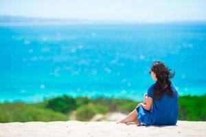 Young happy woman enjoy summer vacation on white sandy beach photo