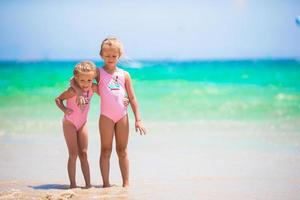 Adorable little girls having fun during beach vacation photo