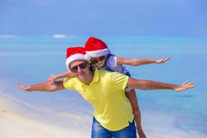 niña y padre feliz en sombreros de santa disfrutan de vacaciones de navidad foto