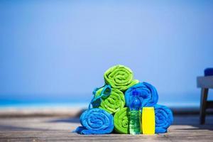 Close up of colorful towels and sunscreen bottle background the sea photo