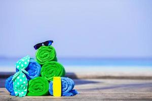 Close up of colorful towels and sunscreen bottle background the sea photo