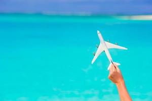 Small white miniature of an airplane on background of turquoise sea photo