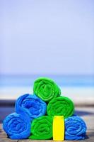 Close up of colorful towels and sunscreen bottle background the sea photo