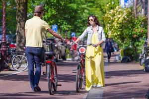 joven pareja feliz en bicicleta en calles antiguas en amsterdam, países bajos foto