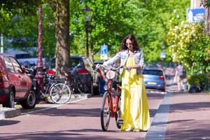 mujer hermosa joven en bicicleta en la ciudad europea foto