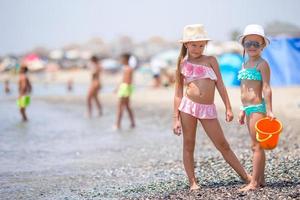 Adorable little girls having fun during beach vacation photo