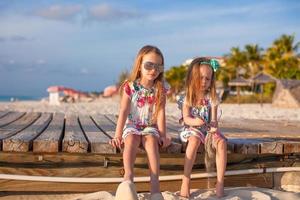 dos niñas felices disfrutan de vacaciones en la playa blanca foto