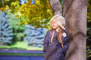 Cute little girl at warm sunny autumn day outdoor photo